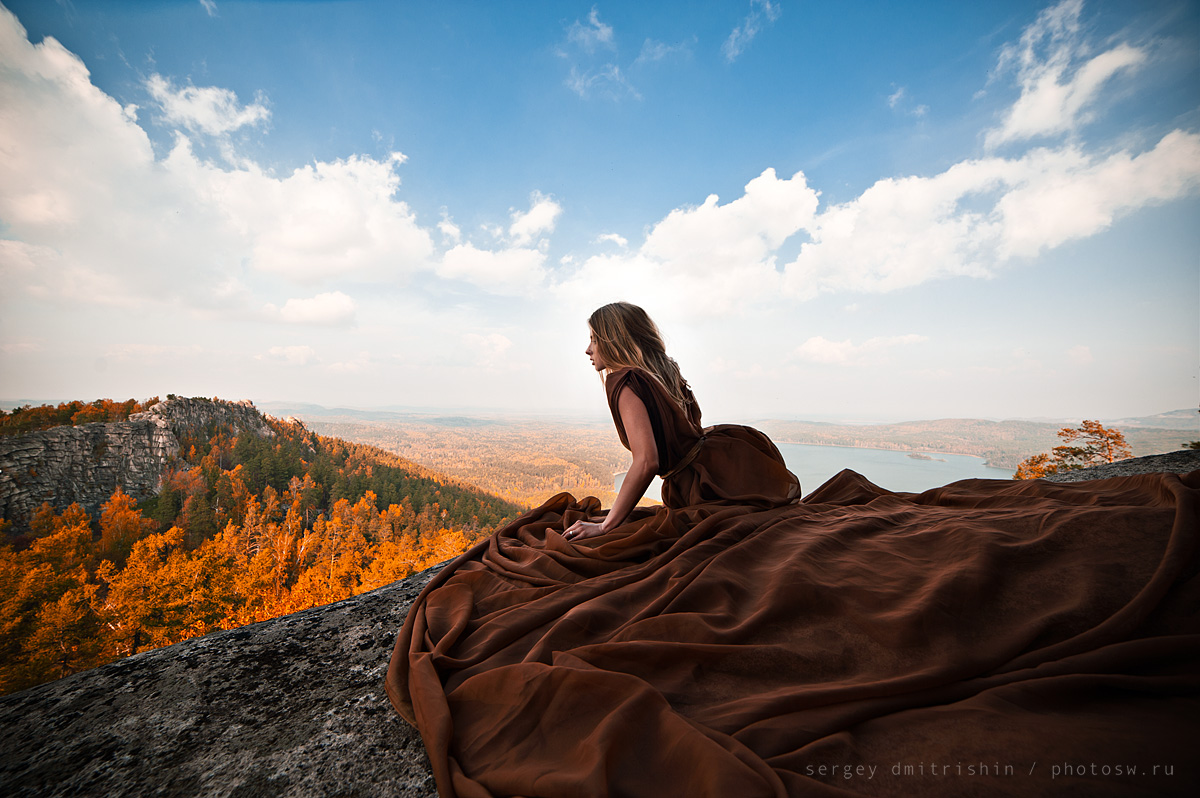 Осенняя фотосессия на Шиханах - девушка в длинном шоколадном платье на краю скалы